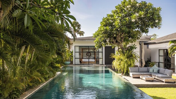 A modern house with a swimming pool surrounded by lush greenery. - Smeralda Villa (Canggu)
