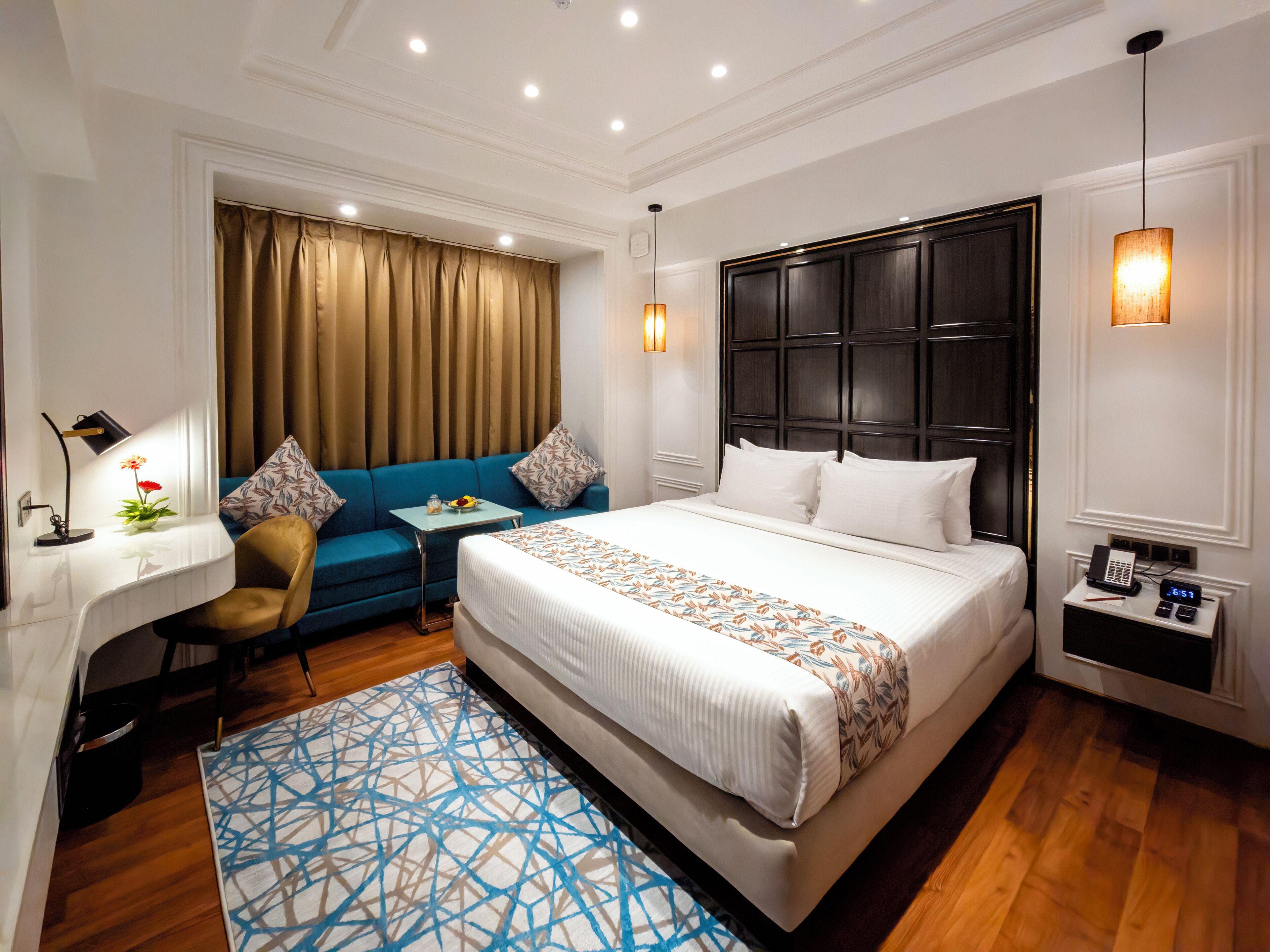 Habitación de hotel con una cama grande, un sofá, un escritorio y una mesita.