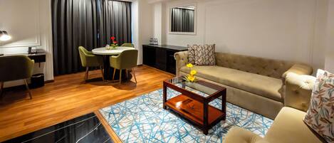 A modern living room with a sofa, coffee table, and dining area.