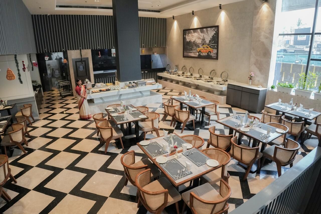 A restaurant with a checkered floor, multiple dining tables, and chairs.