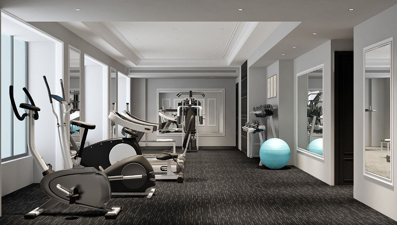 A modern hotel gym with cardio machines, weightlifting equipment, and exercise balls.