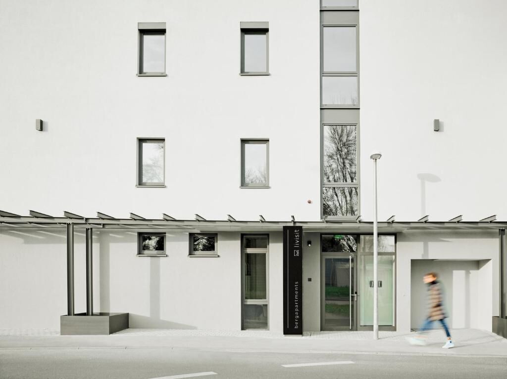 Un edificio moderno con fachada plana, varias ventanas y entrada de cristal.