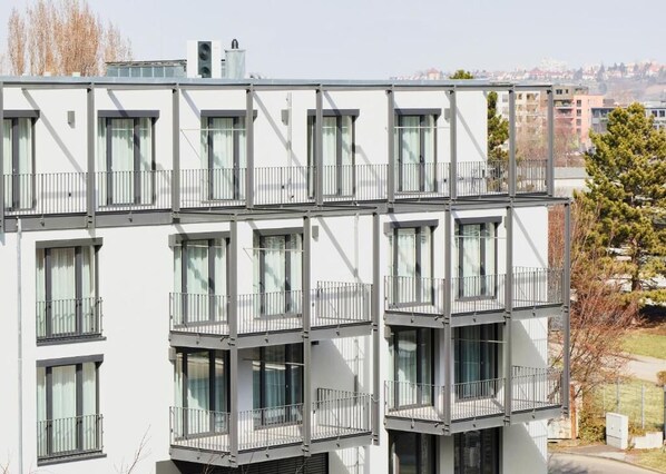 Un immeuble moderne à plusieurs étages, doté de balcons et de grandes fenêtres.