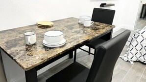 A dining table with plates, cups, and a bowl. - Cozy Private Studio (Quartz Hill)
