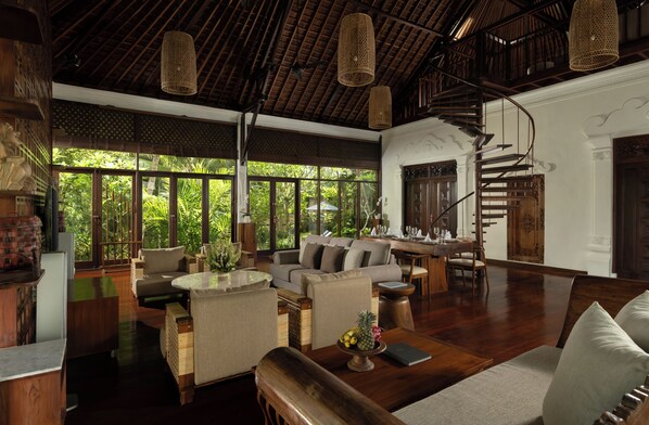A spacious living area with a wooden ceiling, large windows, a staircase, and a dining area. - Villa Leona Ubud (Ubud)