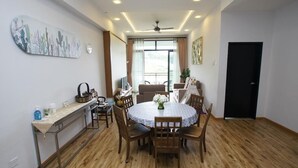 Comedor con una mesa redonda, sillas, una mesa de buffet y un ventilador de techo.