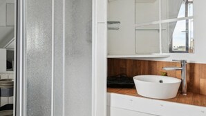 A modern bathroom with a white sink, wooden countertop, and a large mirror. - 1. Studio Porte Dauphine Paris 16ème (Paris)