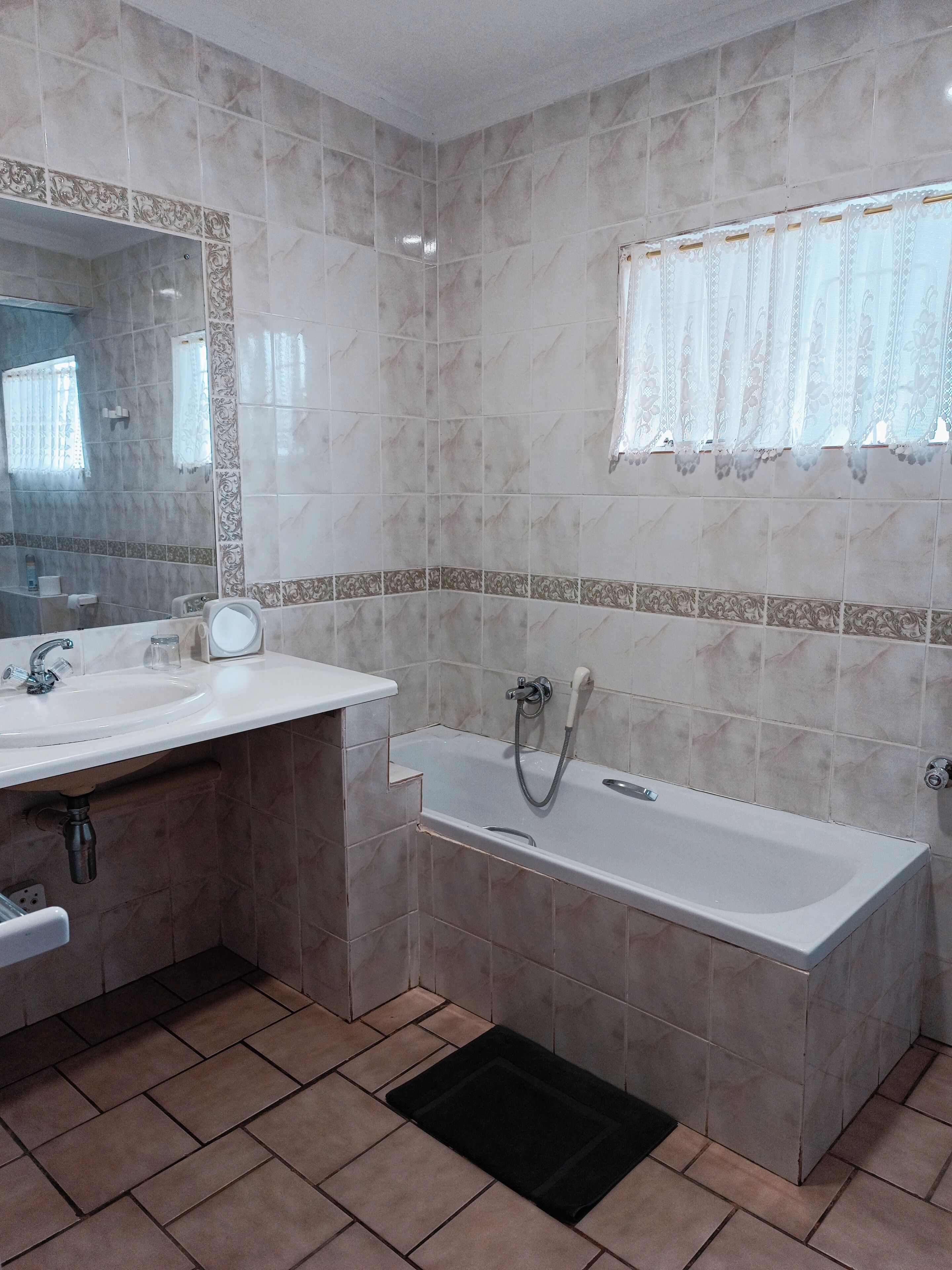 Uma casa de banho com lavatório, espelho e banheira.
