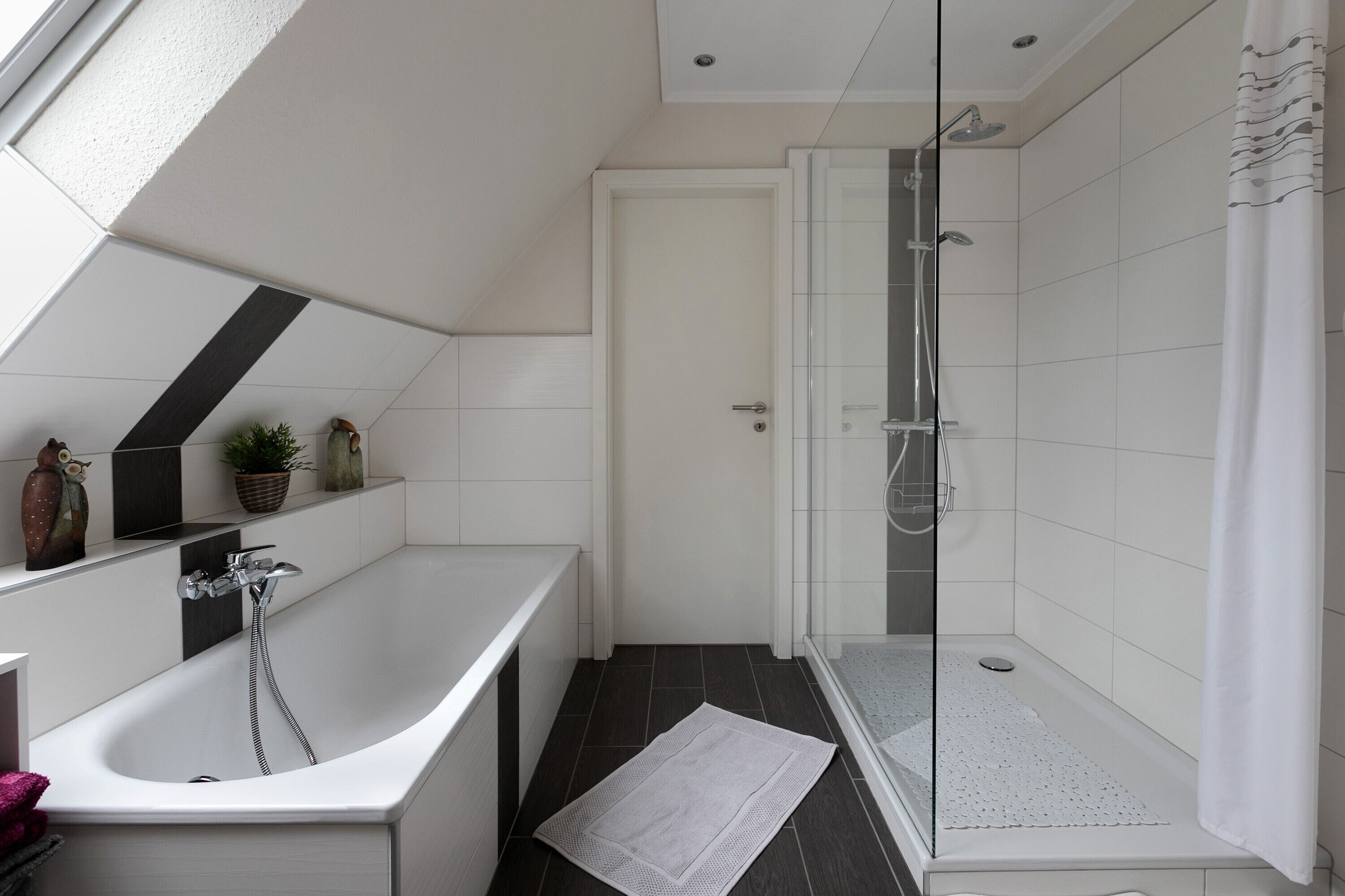 Un bagno moderno con vasca, doccia e area doccia vetrata.