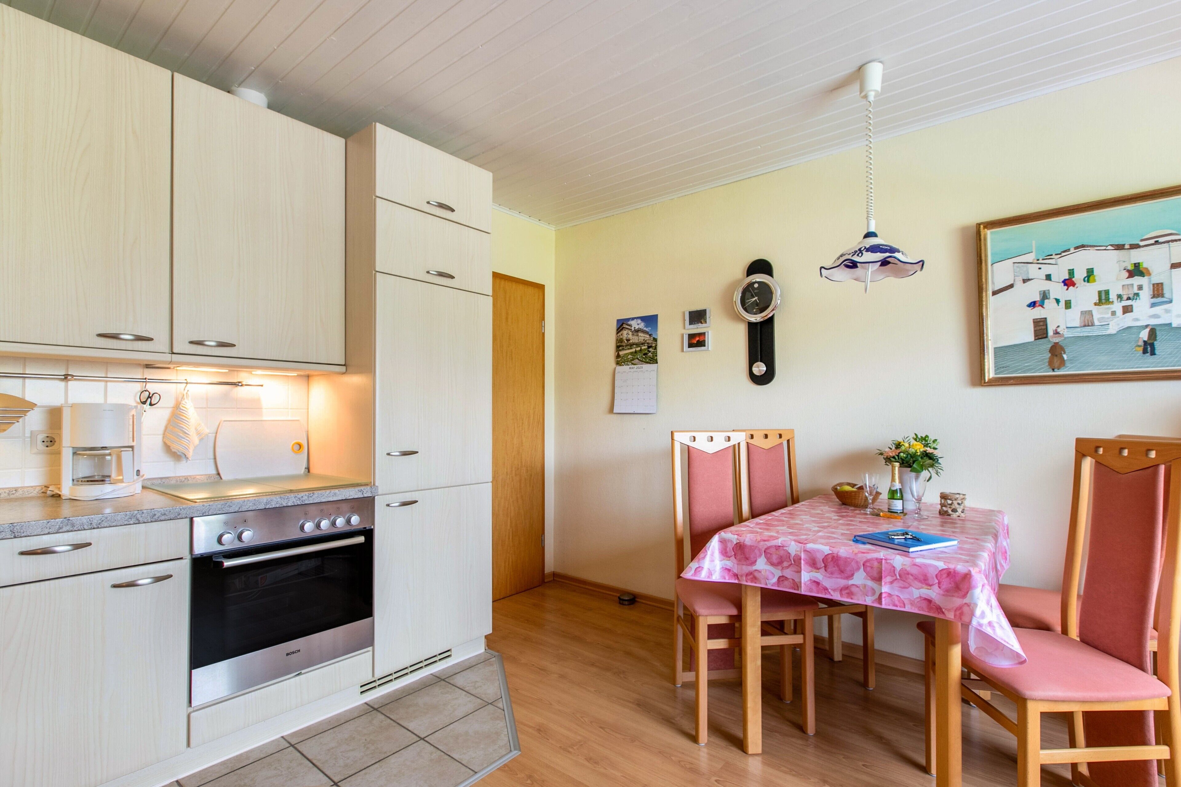Une cuisine équipée d’une cuisinière, d’un four et d’un coin repas avec une table et des chaises.