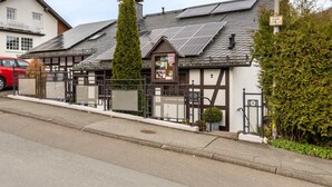 Un bâtiment doté de panneaux solaires, une entrée sécurisée par un portail et un petit panneau indicateur.