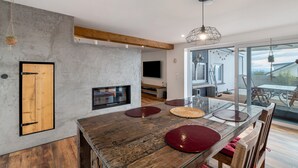 Une cuisine moderne avec une table en bois, un four encastré et une grande fenêtre.