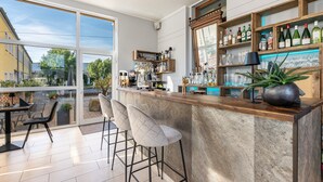 Eine moderne Bar mit einem großen Fenster, Barhocker und Flaschenregalen.