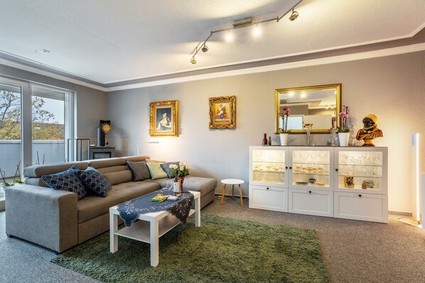 Ein Wohnzimmer mit Sofa, Couchtisch und einer Vitrine.