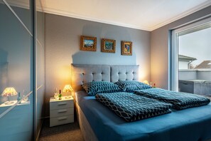 Ein Schlafzimmer mit einem großen Bett, einem Nachttisch mit Lampe und drei gerahmten Bildern an der Wand.