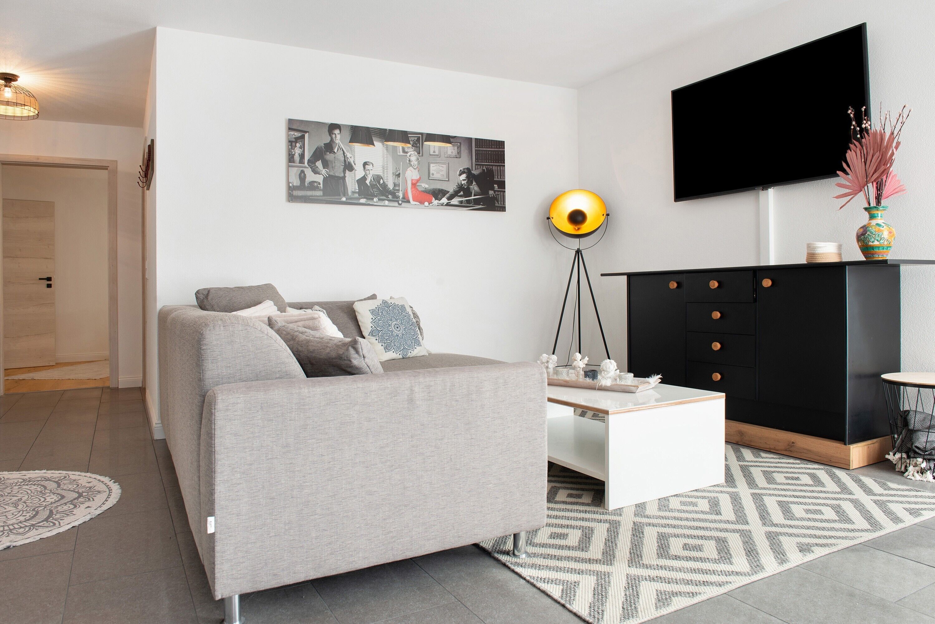 Un salon moderne avec un canapé, une table basse et un meuble noir.