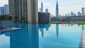 Una piscina con un paisaje urbano de fondo, incluyendo el Burj Khalifa.