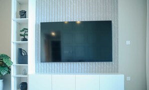 A flat-screen TV mounted on a wall with a tiled backsplash. - Unveil Downtown Luxury 1BR Majestic Skyline Views - Downtown Views ll (Dubai)