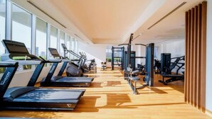 A modern gym with treadmills, stationary bikes, and weight machines. - Stylish Cozy Studio in Bloom Towers, Jumeirah Village Circle – Modern Comfort & City Views (Cosy Studio Apartment in Bloom Towers, Jumeirah Village Circle)