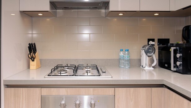 Una cucina moderna con fornello a gas, macchina per caffè e bollitore.