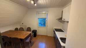 Cocina pequeña y funcional con comedor, ventana con vistas y techo blanco.