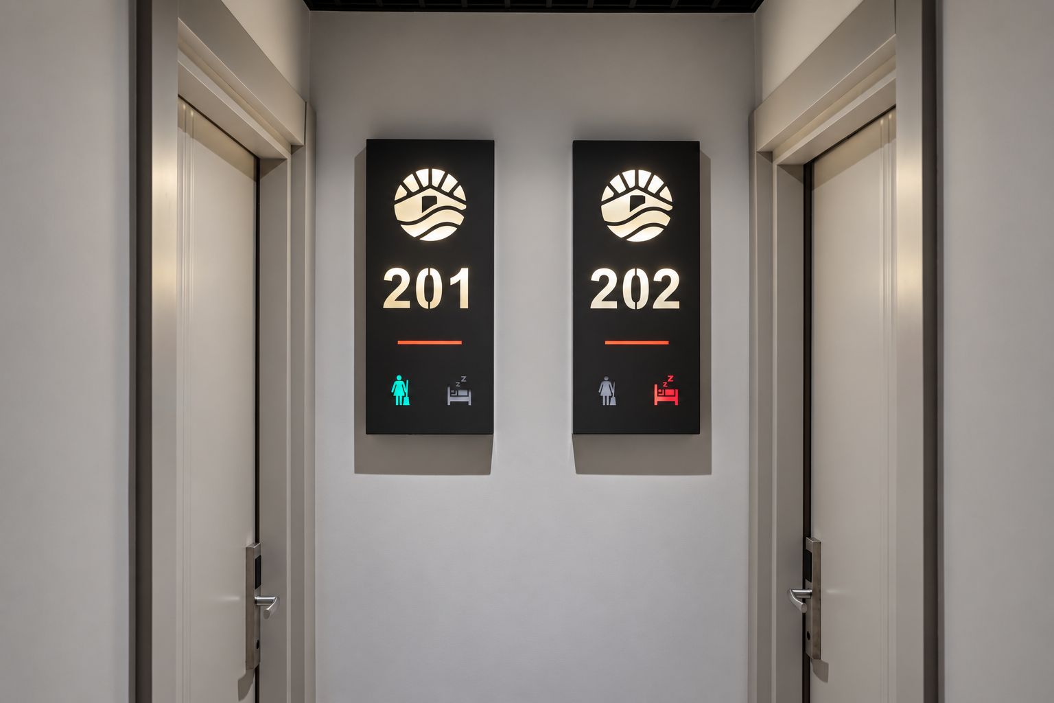 Deux portes, portant les numéros 201 et 202, chacune affichant un symbole représentant un lit et un symbole représentant une personne.