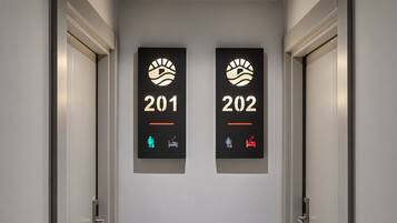 Deux portes, portant les numéros 201 et 202, chacune affichant un symbole représentant un lit et un symbole représentant une personne.