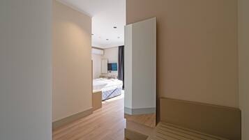 A modern hotel room with a bed, a flat-screen TV, and a large window.