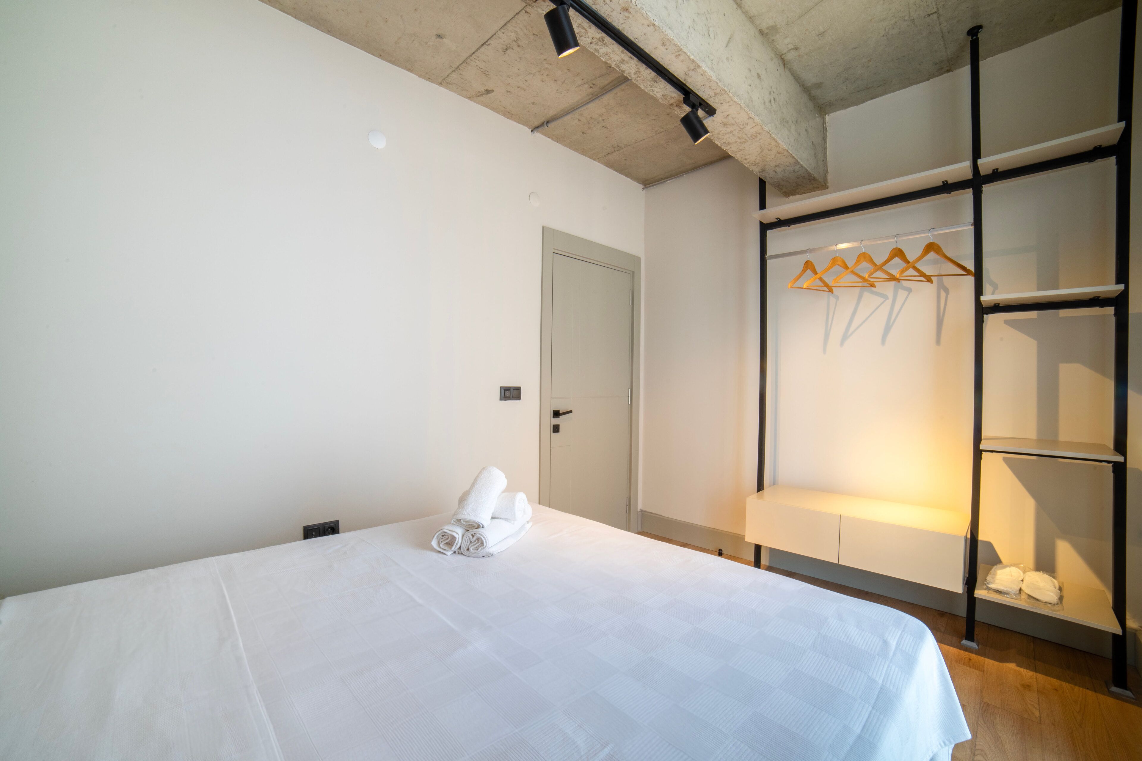 Un dormitorio con cama, armario y puerta.