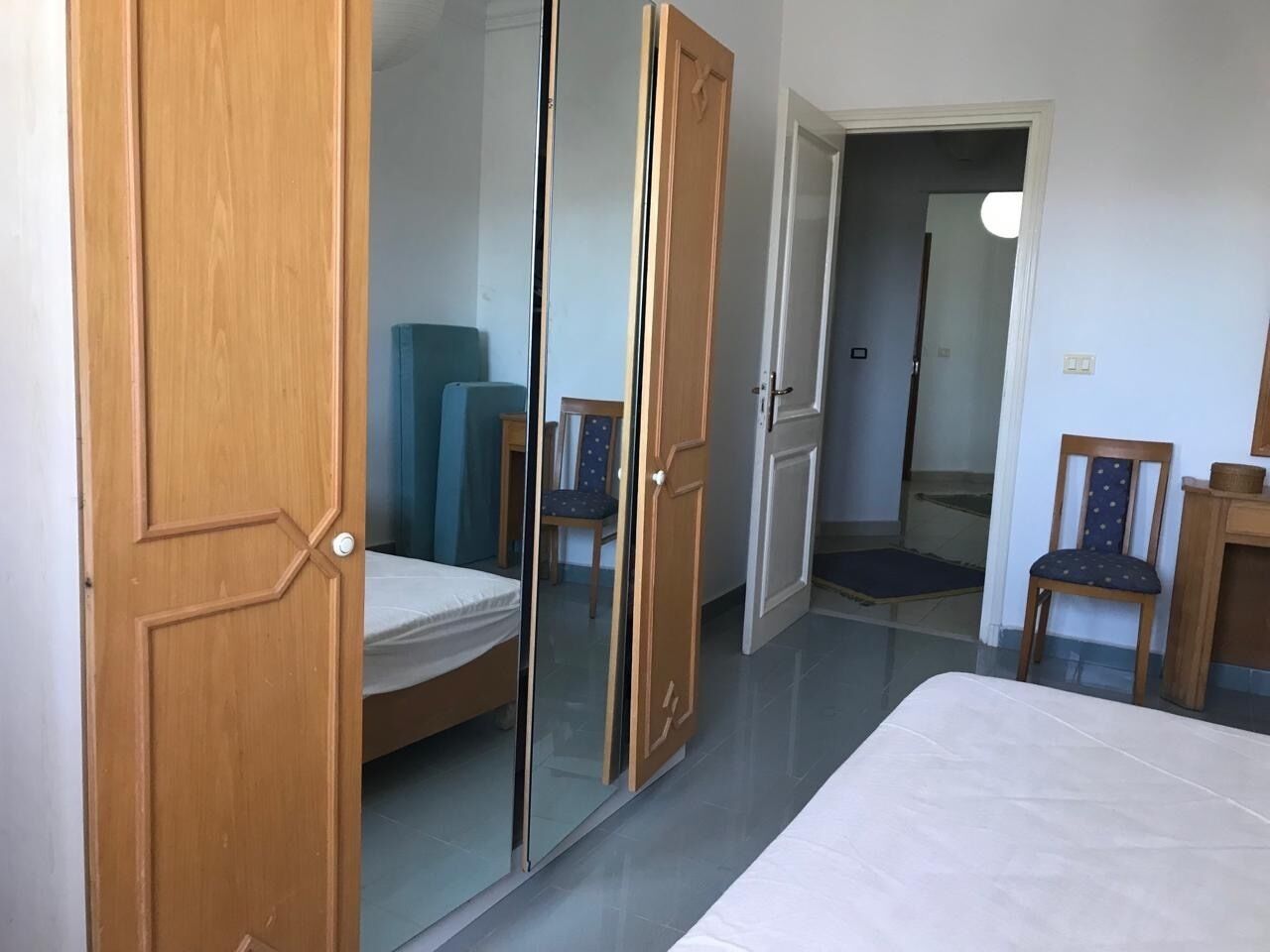Une chambre à coucher avec un lit, une armoire et une chaise.