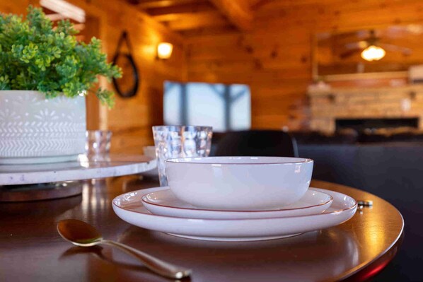A dining table with a white bowl and saucer, a spoon, and a potted plant. - Upscale Cabin Stunning Views Hot Tub Game Room (Sevierville)