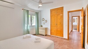 Simple, stylish room with a single bed, bedside table, and large wardrobe.