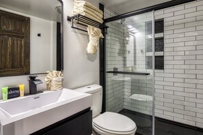 A modern bathroom with a white sink, a toilet, and a glass-enclosed shower. - Modern Style 2 Bed Condo Pool in Gatlinburg (Gatlinburg)