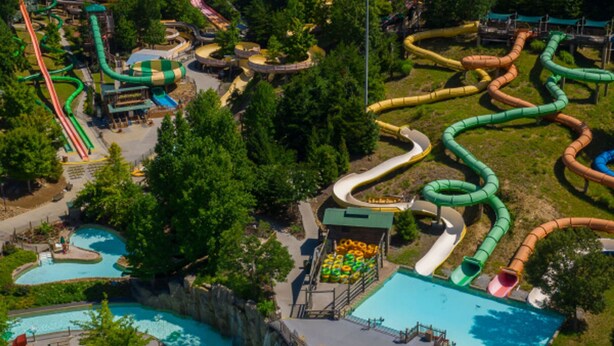 Vue aérienne d’un parc aquatique avec de nombreux toboggans et plusieurs piscines.