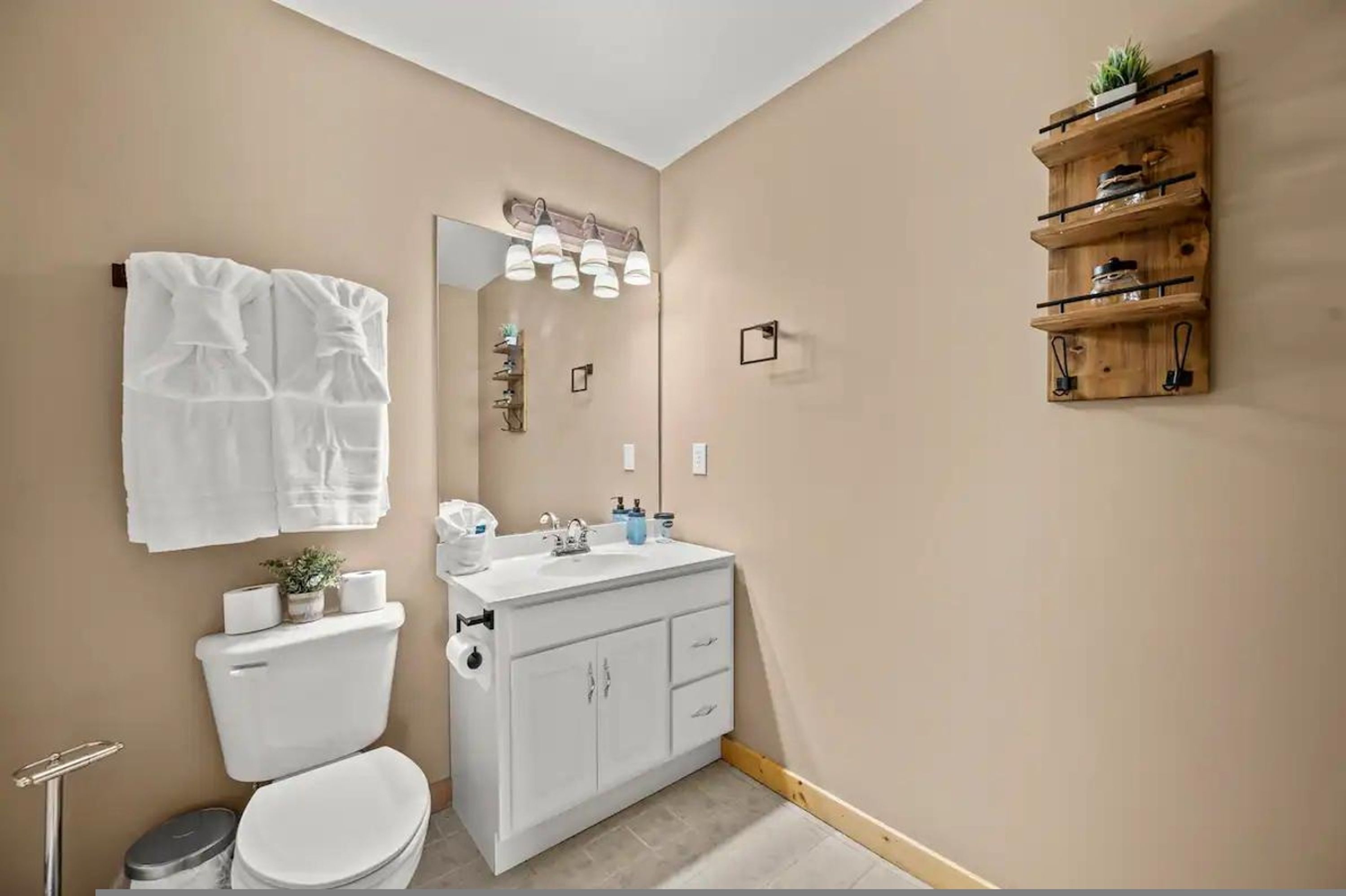A bathroom with a toilet, sink, and towel rack.