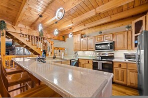 Una cocina moderna con armarios de madera, electrodomésticos de acero inoxidable y una isla central.