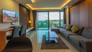 A modern living room with a sofa, coffee table, and TV. - Best Sea View 500m 2 Beach Modern C1 (Rawai)