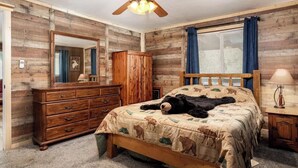 A bedroom with a wooden bed, a dresser, a mirror, and a ceiling fan. - The Lone Pine (Heber-Overgaard)