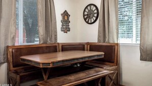 A corner booth with a wooden table and bench, a wall clock, and a rustic wall decoration. - The Lone Pine (Heber-Overgaard)