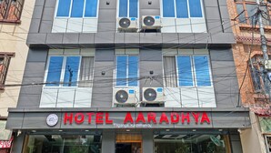 A multi-story hotel with a modern facade, air conditioning units, and a sign indicating it is located in Tilganga, Kathmandu. - Hotel Aaradhya (Kathmandu)