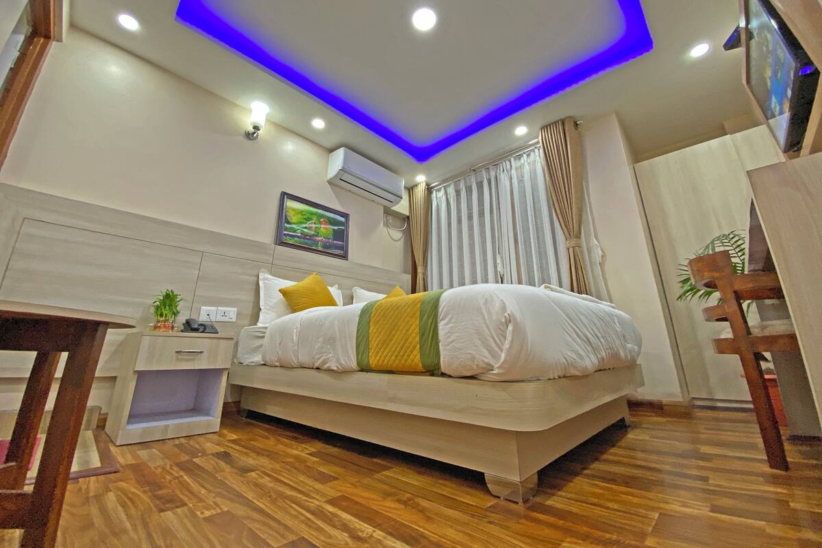 A modern bedroom with a bed, bedside table, and a small desk.