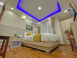 A modern bedroom with a bed, bedside table, and a small desk. - Hotel Aaradhya (Kathmandu)