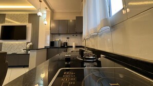 Eine moderne Küche mit Kochinsel, integrierten Geräten und einem Flachbildfernseher.