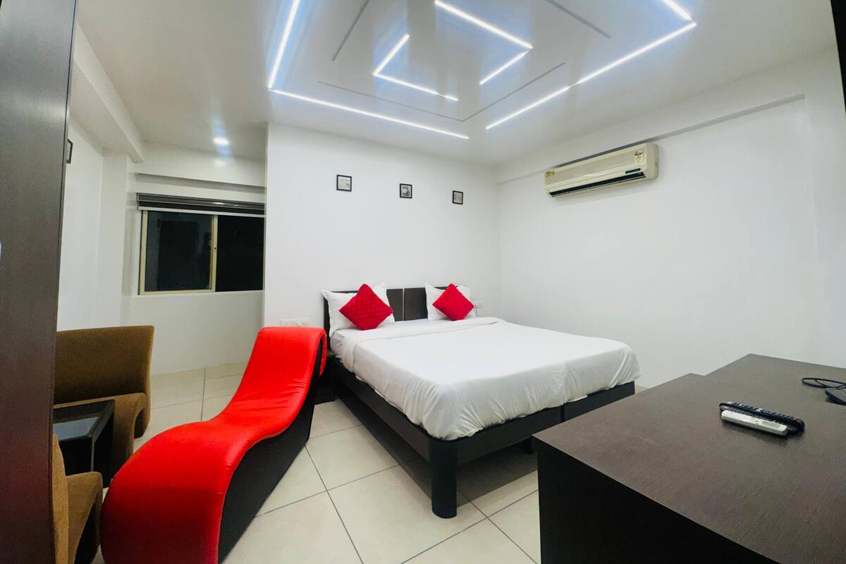Une chambre d’hôtel moderne, équipée d’un lit, d’un bureau et d’une chaise.