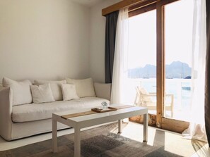 Suite – junior, sjøutsikt | Oppholdsområde | En 75-tommers Flatskjerm-TV med Parabol-TV