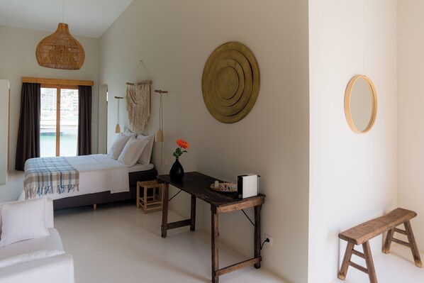 Une chambre à coucher avec un lit, une table de chevet et une décoration murale en macramé.