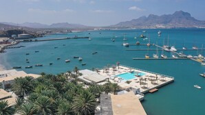 Un port de plaisance avec des bateaux, une piscine et des palmiers.