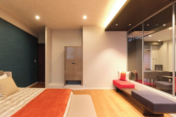 Relax in a spacious room with a large bed, seating area, and wardrobe.