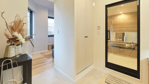Un baño moderno con un espejo grande, zona de ducha y un inodoro.