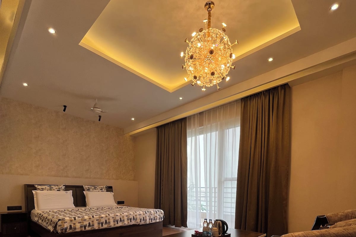 A modern bedroom with a large bed, a coffee table, and a sofa.